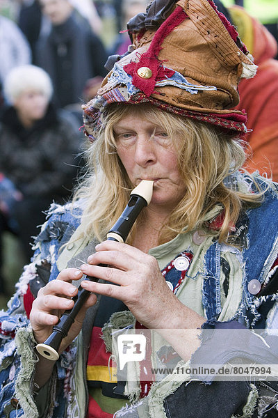 United Kingdom  England  Woman playing flute at Stonehenge festival  Wiltshire