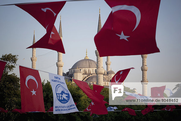 Turkey  Istanbul  Turkish flags flapping in breeze at dusk over Blue Mosque  Sultanahmet