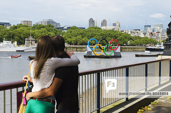 Couple looking at Olympic Rings on Thames River  South Bank  London  England  United Kingdom