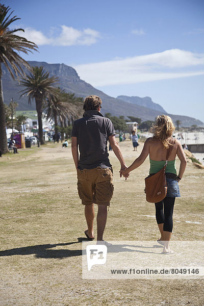 South Africa  Cape Town  Couple walking down sea promenade  Camps Bay
