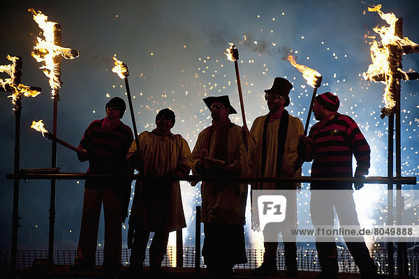 People dressed as clergy on stand with fireworks behind them at Newick Bonfire Night  East Sussex  England  UK