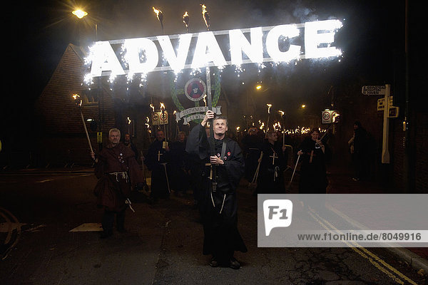 Man dressed as monk carrying 'Advance' banner on Bonfire Night  Lewes  East Sussex  England