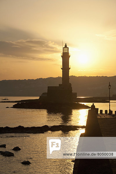 Silhouette of lighthouse at harbor entrance at dawn  Chania  Crete  Greece