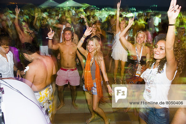 Festival revellers dancing around pool at night Coma festival  Al Maya Island  Abu Dhabi  UAE