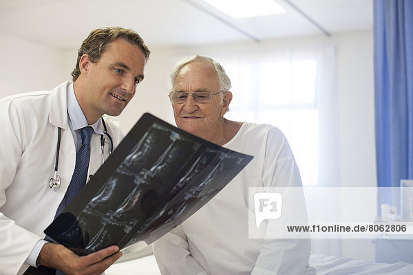 Arzt und Patient bei der Röntgenuntersuchung im Krankenhauszimmer