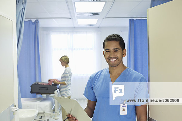 Nurse holding clipboard in hospital room