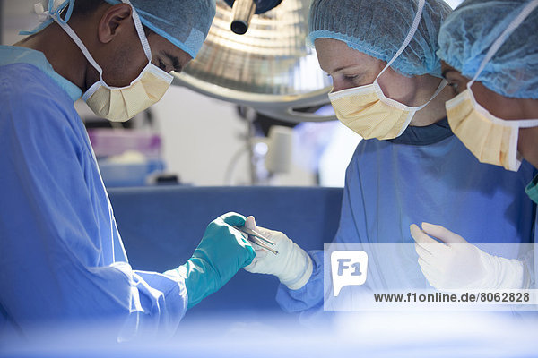 Über den Patienten gebeugte Chirurgen auf dem Operationstisch