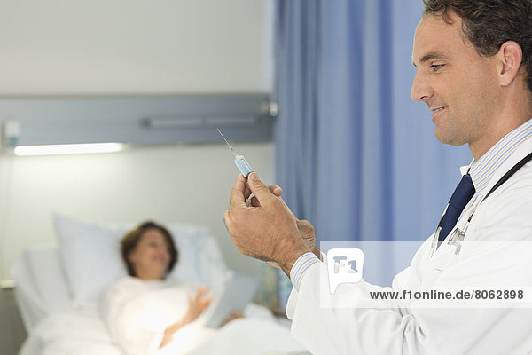 Arzt überprüft Spritze im Krankenhauszimmer