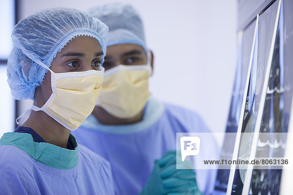 Chirurgen untersuchen Röntgenaufnahmen im Krankenhauszimmer