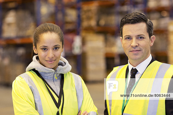 Businessman and worker smiling in warehouse