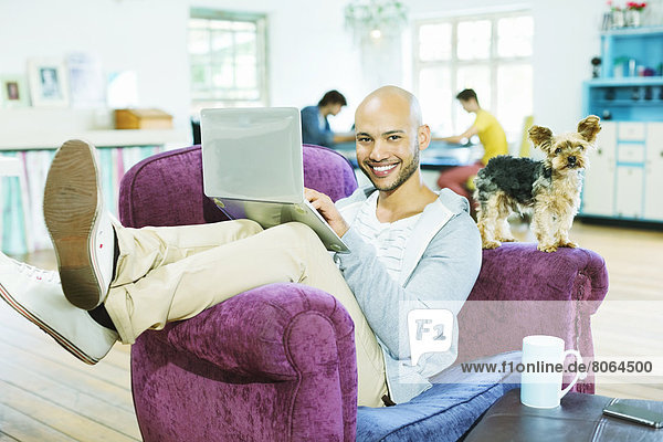 Man using laptop in armchair