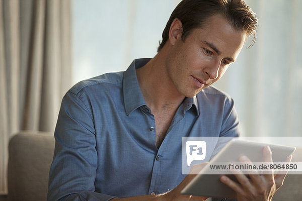 Businessman using tablet computer on sofa