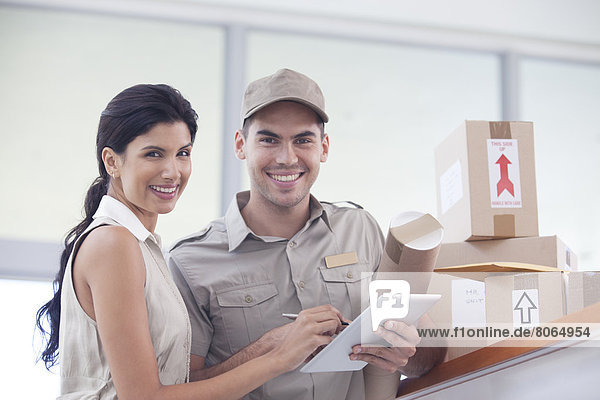 Woman signing for packages from delivery boy