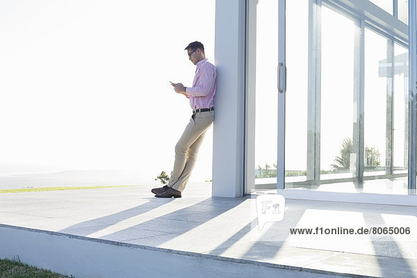 Businessman using cell phone outside office