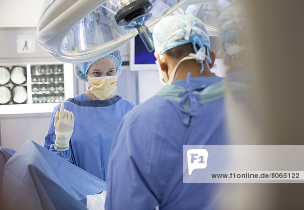 Chirurgen stehen über dem Patienten im Operationssaal