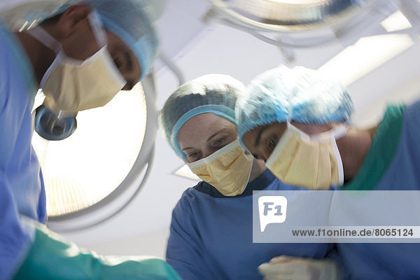 Über den Patienten gebeugte Chirurgen im Operationssaal