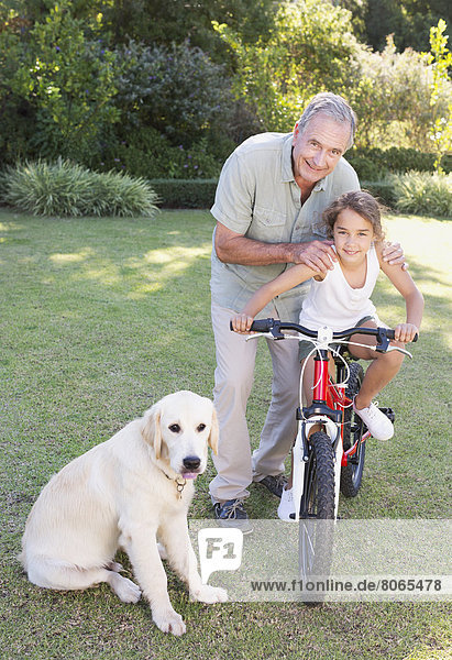 Older man with granddaughter and dog