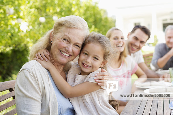Older woman and granddaughter smiling outdoors