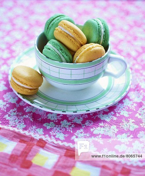 Grüne und gelbe Macarons in einer Tasse