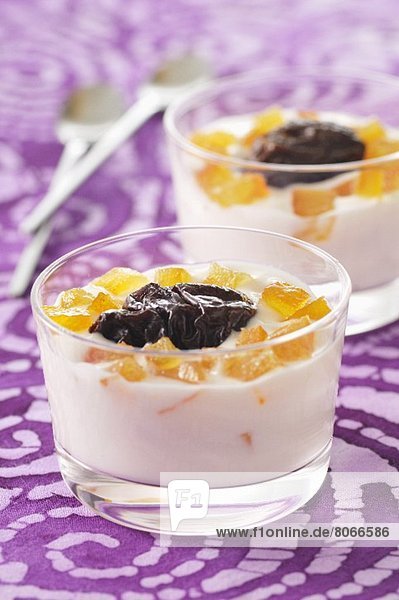 Creamy dessert with preserved prunes and crystallised fruit