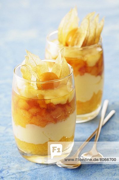 A layered dessert with apricots  caramel mousse and physalis