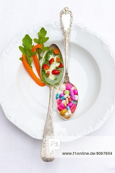 A spoonful of herb sauce with peppers and a spoonful of vitamin pills