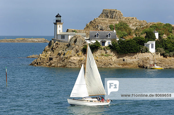 Sailboat in front of the lighthouse and the keeper's house on Louet Island in the Bay of Morlaix (29). The lighthouse keeper's house can be rented. Unusual housing