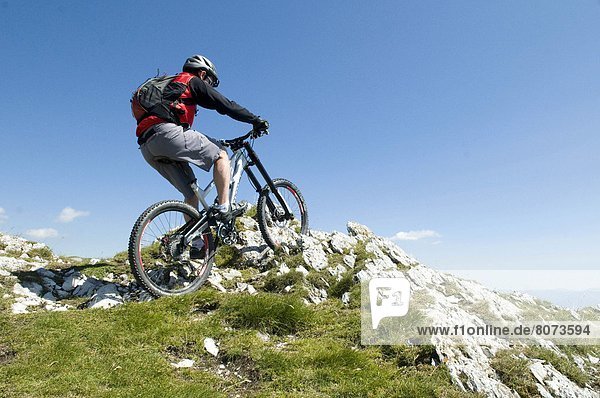 'Mountain pass ''Col du Rousset'' (26). 2011/07/04. Moutain biking with a German Bionicon variable-geometry full suspension mountain bike. Mountain biker wearing a helmet  facing the panorama on the mountains of Diois  mountain in the Pre-Alps.'