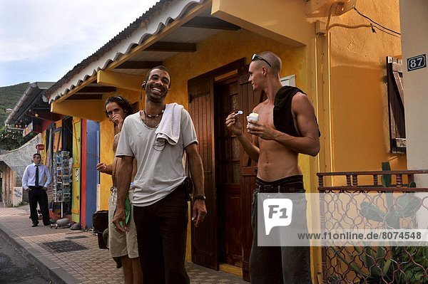 Guadeloupe (971): village of Deshaies on the northwest coast of Basse-Terre Island. Everyday life  young men in front of a house in the street  smile