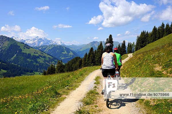 Couple riding mountain bikes in the Swiss Alps.