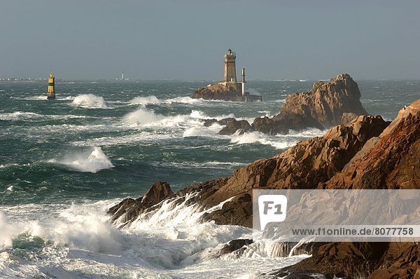 'The ''Pointe du Raz'' headland and its two lighthouses  ''La Vieille'' and ''La Plate''  with a choppy sea breaking against the cliff and Cap Sizun (headland) in the background.'