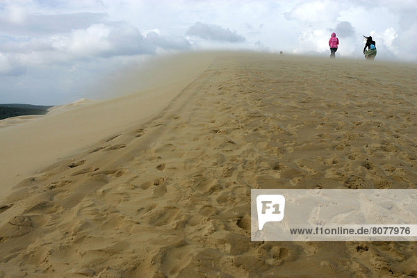 Wind on the dune of Pilat (or Pyla) in the Arcachon Bay (Gironde  Aquitaine  France) Two women having a walk on the top