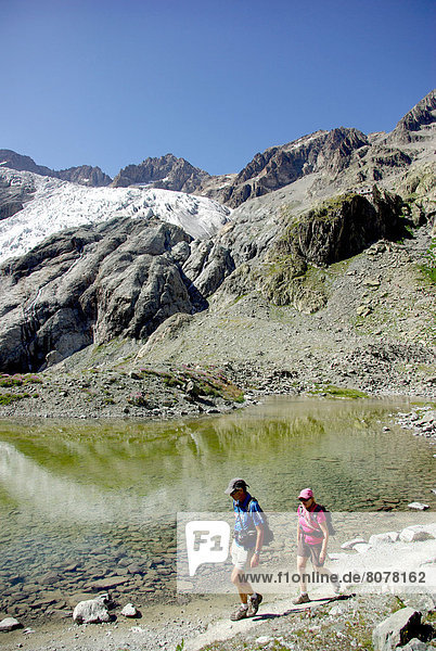 ecrins National Park (05) : Hikers by a tarn at an elevation of 2 348 m  at the bottom of the Glacier Blanc (White Glacier)