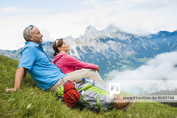 Couple sitting on a meadow  Neunerkoepfle  Allgaeu Alps  Tannheim Valley  Tyrol  Austria  Europe