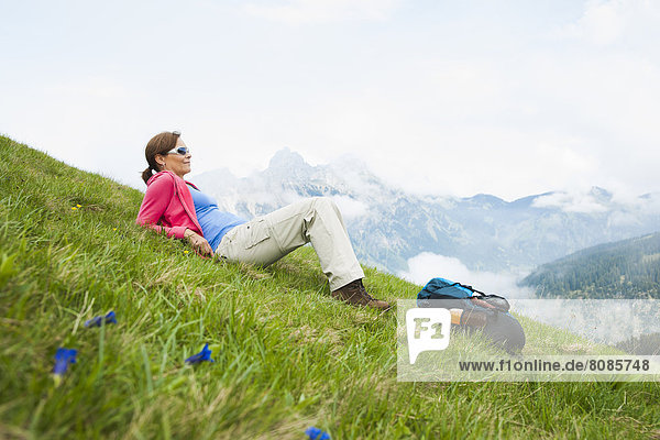 Woman lying on a meadow  Neunerkoepfle  Allgaeu Alps  Tannheim Valley  Tyrol  Austria  Europe