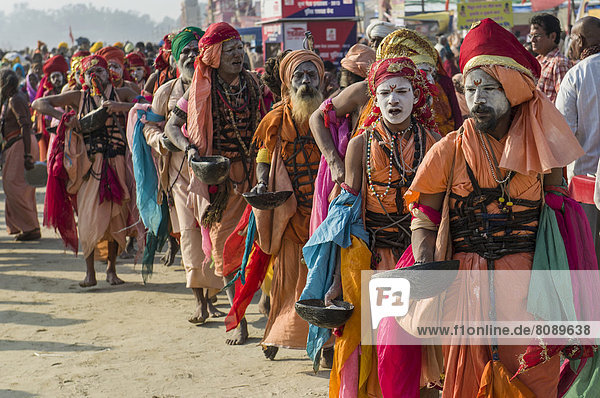 Group of Gudar Sadhus  holy men  walking in a row and collecting offered food from fellow sadhus  at the Sangam  the confluence of the rivers Ganges  Yamuna and Saraswati  during Kumbha Mela festival