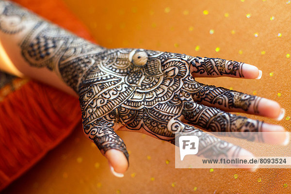 Close up of hand with intricate henna design