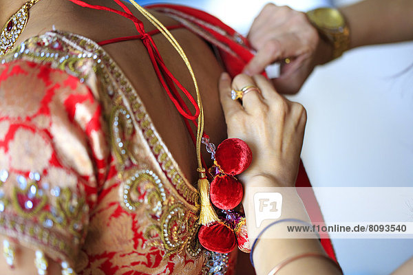 Dressmaker adjusting traditional Indian dress