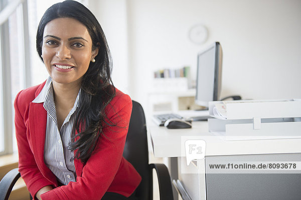 Indian businesswoman smiling at desk