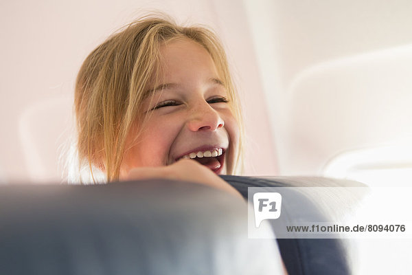 Caucasian girl laughing on airplane