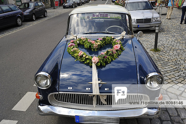 Blue Opel Rekord P1 car  in use as a wedding car with floral decorations on the hood