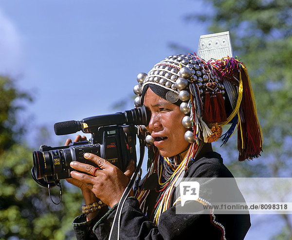Akha-Frau in traditioneller Kleidung  Kopfbedeckung mit Silberglocken  mit Videokamera Canovision A1 Hi8