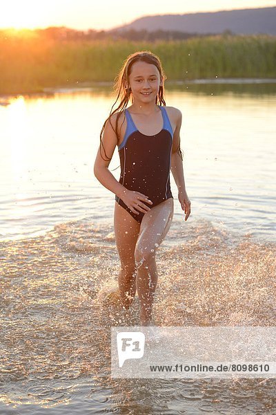Mädchen läuft im seichten Wasser eines Sees