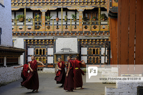 Eine Gruppe junger Mönche übt im Innenhof des Dzongs von Mongar einen religiösen Tanz