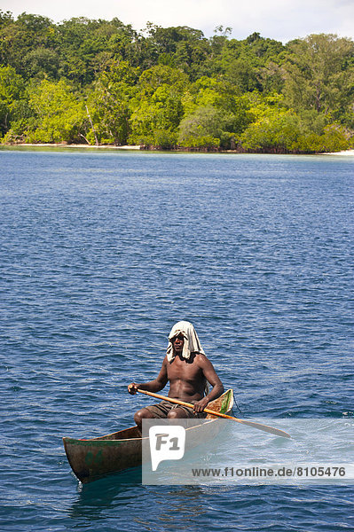Mann paddelt in seinem Kanu