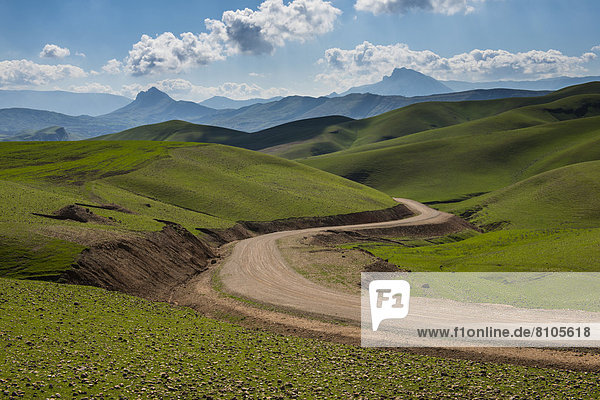 Straße windet sich durch die grüne Hügellandschaft  an der Grenze zum Iran