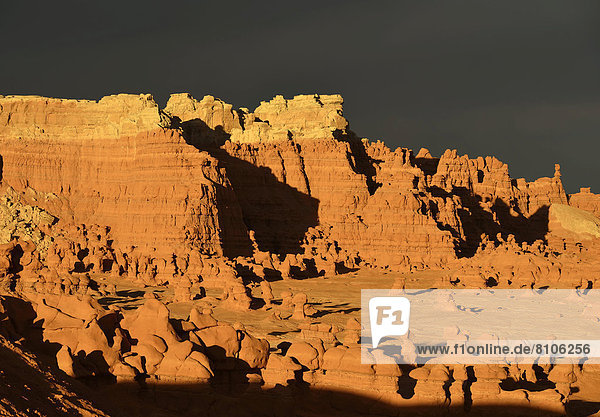 Erodierte Hoodoos und Felsformationen aus Entrada-Sandstein im Morgenlicht  hinten dunkle Wolken
