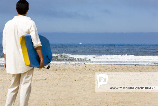 Man On Beach With Surfboard