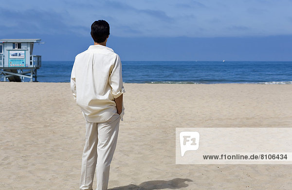 Man Looking At Ocean From The Beach