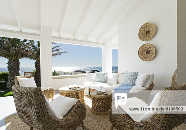Korbsofa und Stühle auf luxuriöser Terrasse